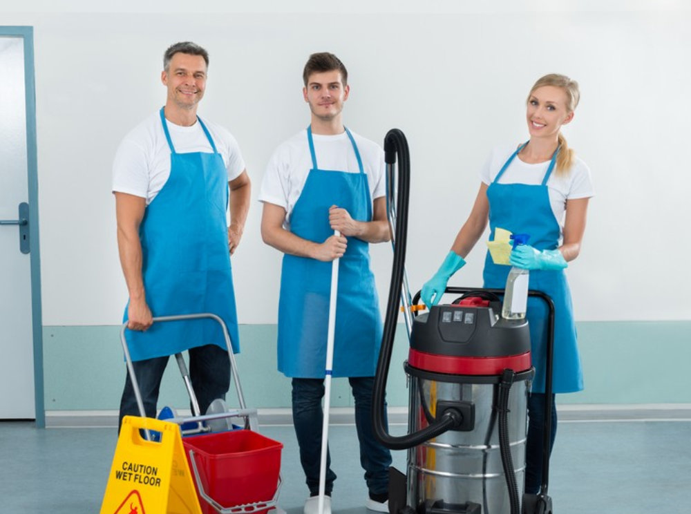 Portrait Of Happy Three Workers With Cleaning Equipments